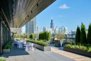 Commercial rooftop terrace featuring Mbrico reinforced porcelain pavers, landscaped planters, outdoor seating, and panoramic views of the Chicago skyline.